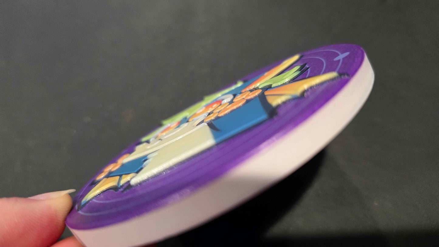 A close-up of a hand holding a round, white and purple disc with colorful printed graphics on a dark gray background.